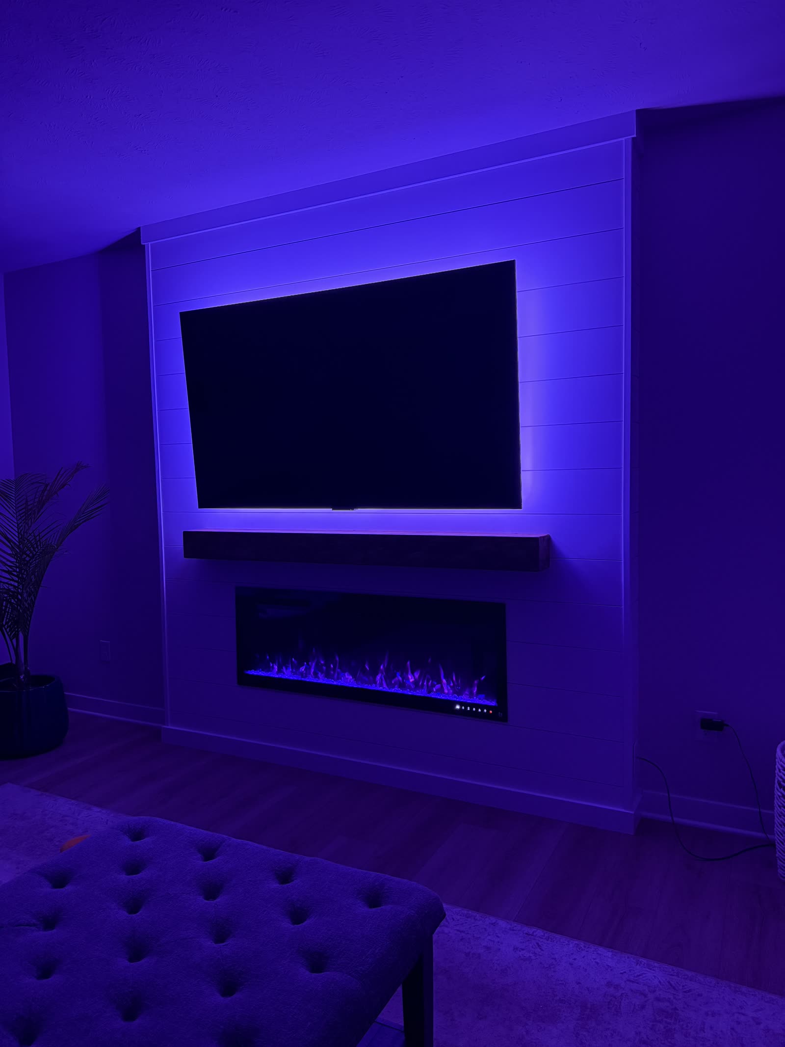 Media wall with blue LED edge backlighting around the TV and fireplace
