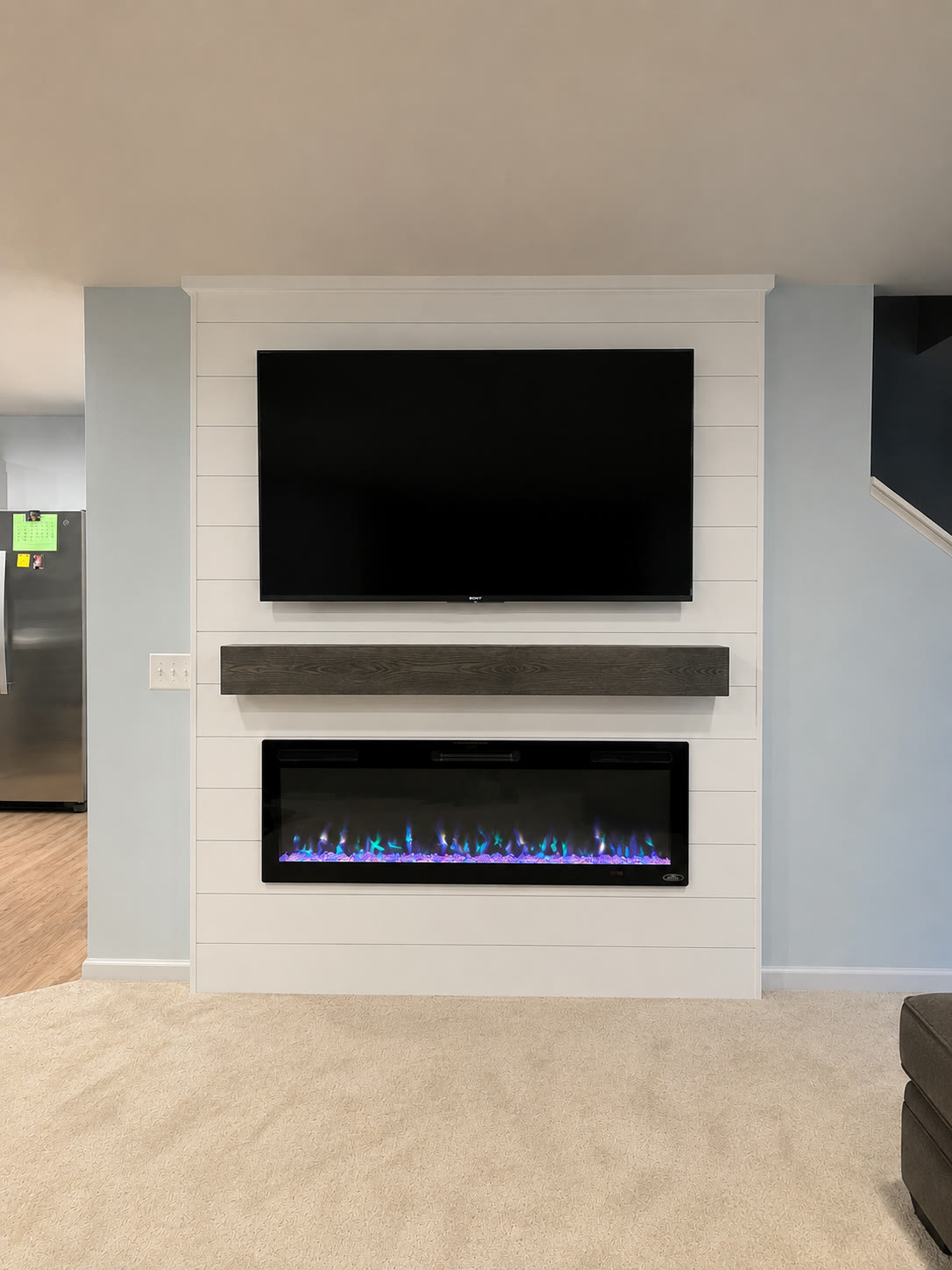 White shiplap accent wall with floating mantel and electric fireplace